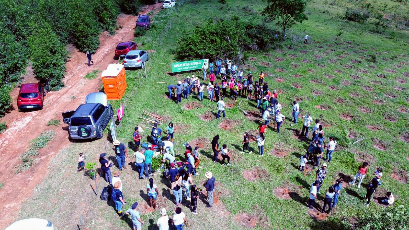 Vista aérea da comunidade reunida com a faixa do Fruto Urbano