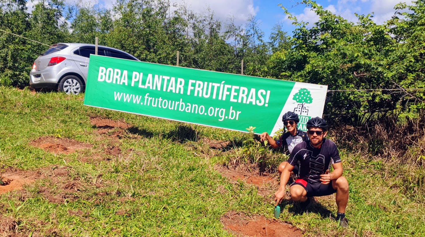 Participante junto à faixa Bora Plantar Frutíferas do Fruto Urbano